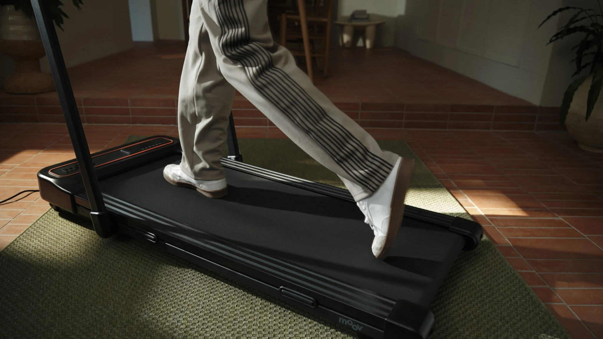 Person walking on a Moov treadmill at home highlighting movement, health, and active lifestyle technology.